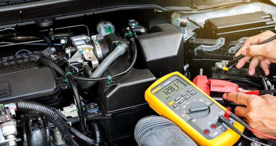 Car mechanic is using a multimeter with voltage range measurement to check the voltage level of the car battery. Car mechanic is using a multimeter with voltage range measurement to check the voltage level of the car battery.