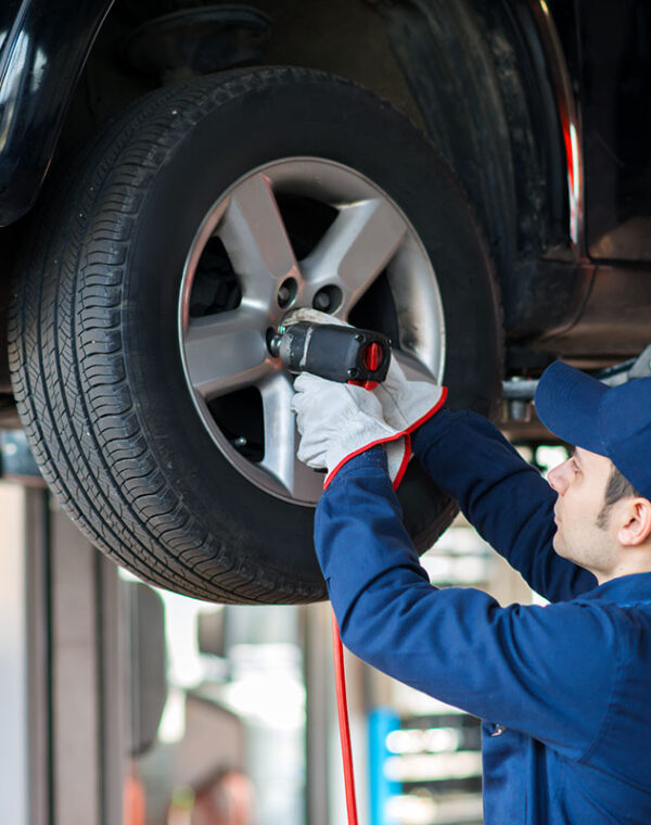 Portrait of a mechanic replacing a wheel
